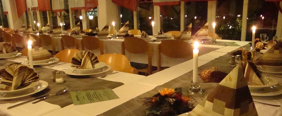 Festlich eingedeckte Tafel bei Kerzenlicht